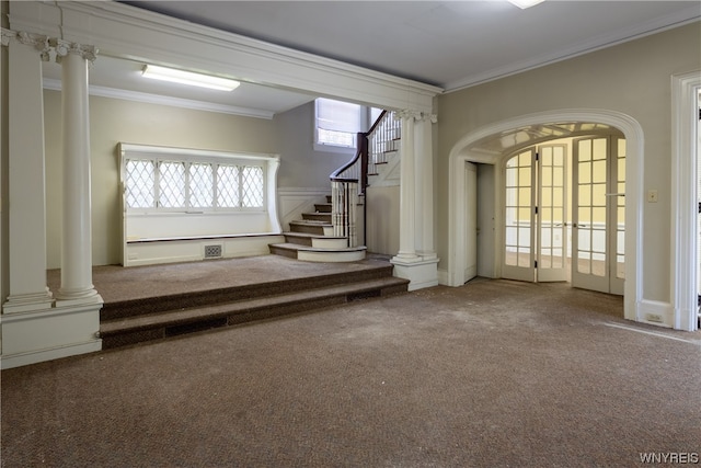 interior space featuring crown molding, ornate columns, and dark colored carpet