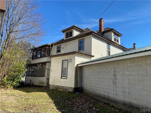 rear view of property with a lawn and a chimney