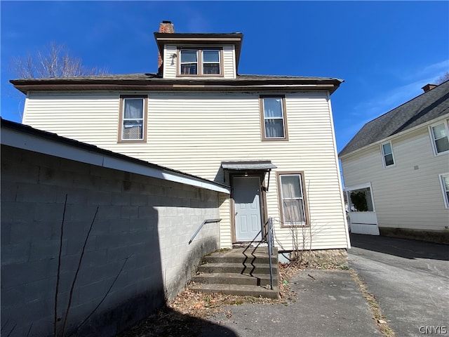 back of property with a chimney