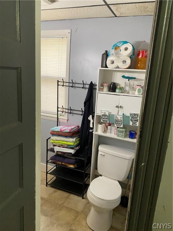 bathroom with a drop ceiling and toilet