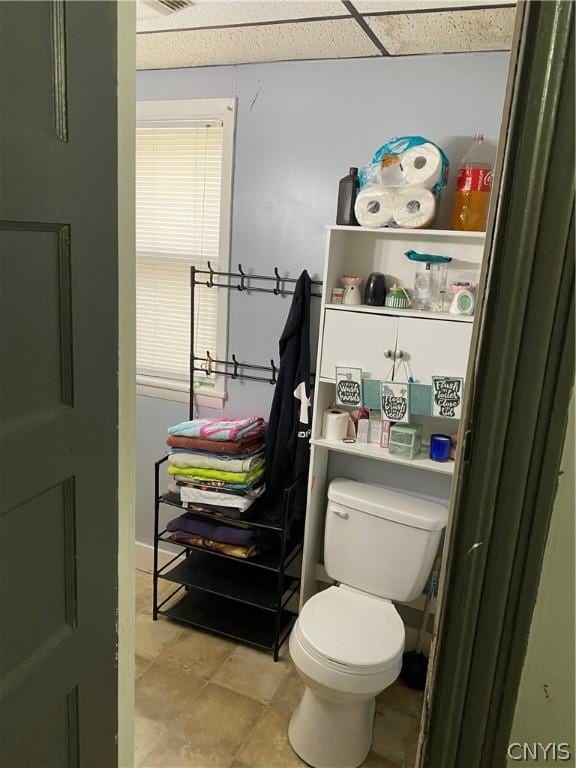 bathroom featuring a paneled ceiling and toilet