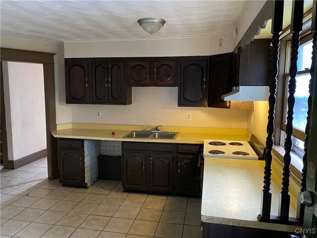 kitchen featuring light tile patterned floors, ventilation hood, dark brown cabinets, sink, and electric range