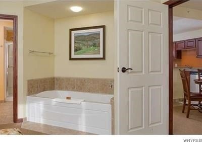 bathroom featuring tile floors and a bath