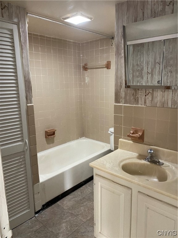 bathroom featuring tiled shower / bath combo, tile floors, and vanity