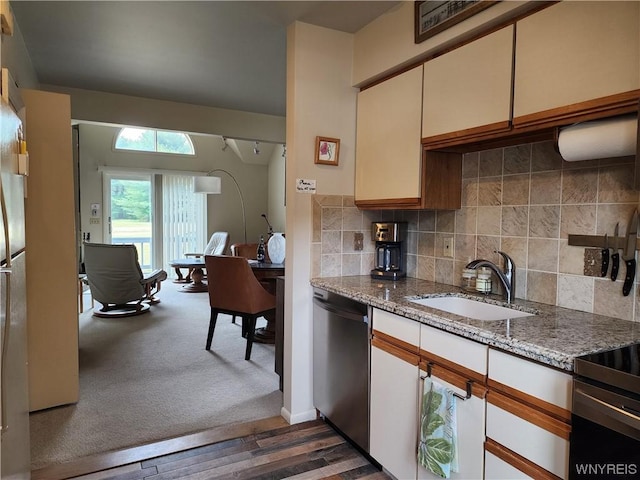 kitchen with decorative backsplash, light stone countertops, sink, dishwasher, and dark hardwood / wood-style floors