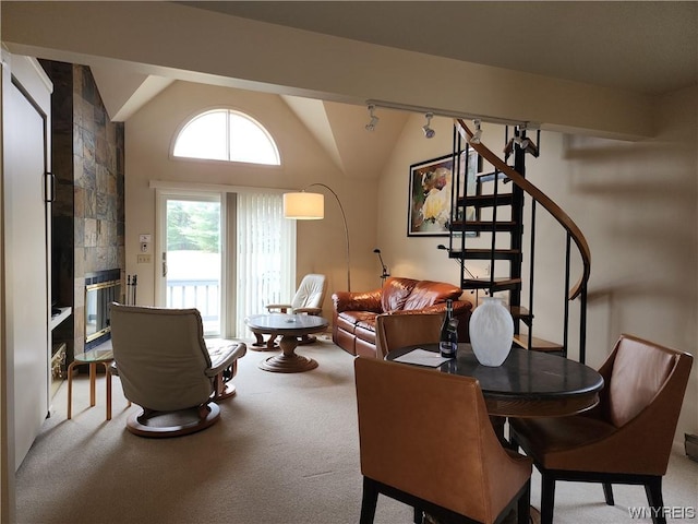 interior space featuring a tiled fireplace, carpet floors, and vaulted ceiling