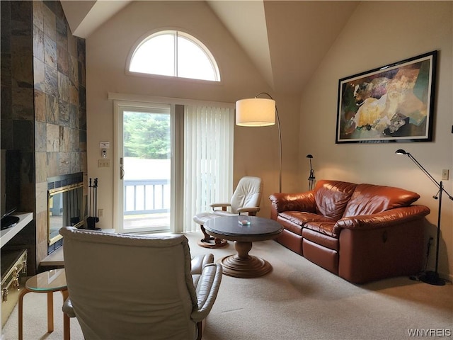 living room with carpet, high vaulted ceiling, and a tile fireplace