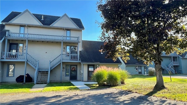 view of front of property featuring a front yard and a balcony