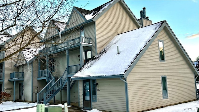 snow covered property with a balcony