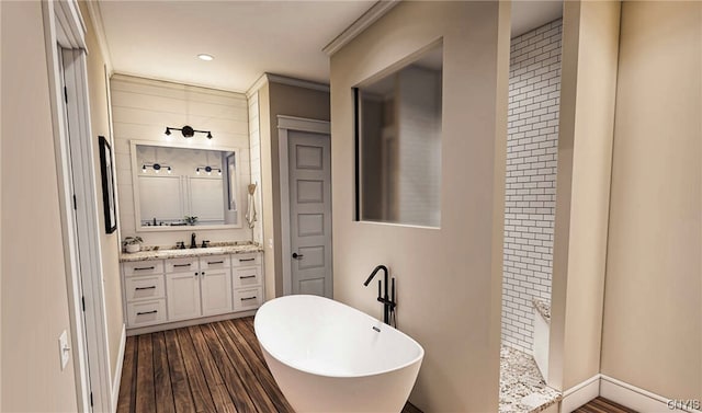 bathroom featuring crown molding, walk in shower, vanity with extensive cabinet space, and hardwood / wood-style flooring