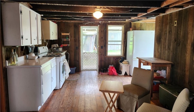 151 Schultz Rd, Sanford, NY 13754 - kitchen with wooden walls, light countertops, light wood-style floors, white appliances, and white cabinetry