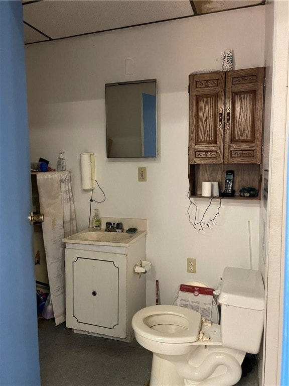 bathroom featuring toilet, vanity, and a paneled ceiling