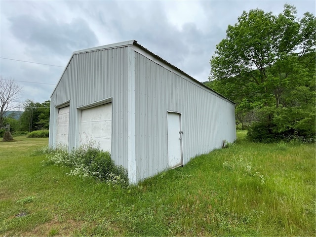 view of shed / structure featuring a lawn and a garage