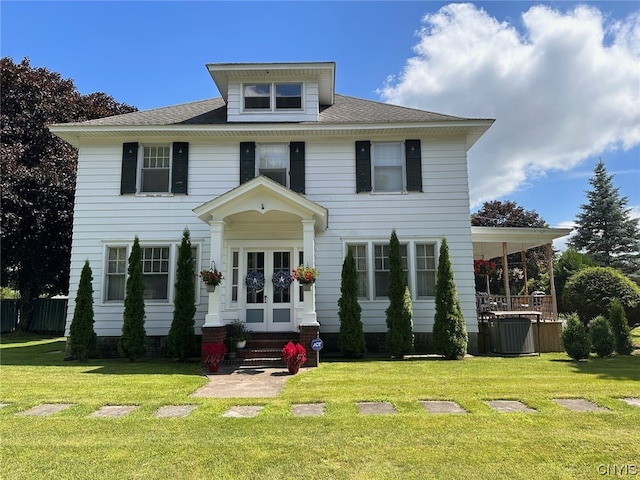 colonial house featuring central AC unit and a front yard