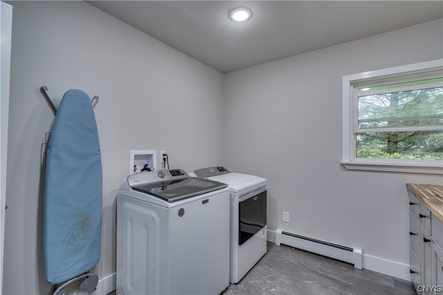 clothes washing area featuring hookup for a washing machine, cabinets, independent washer and dryer, and baseboard heating