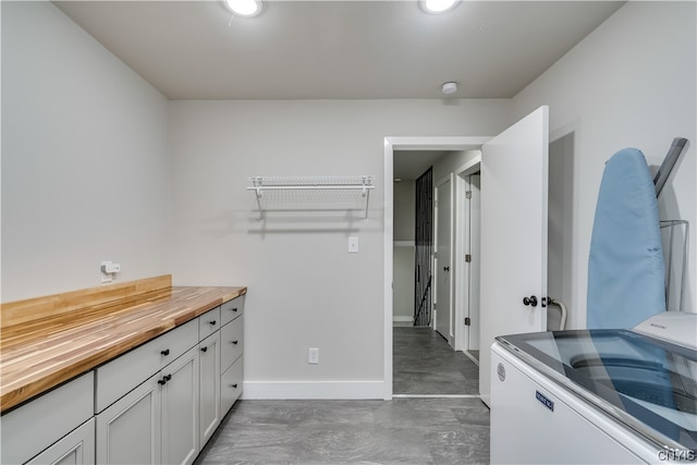 bathroom featuring concrete flooring and washer / dryer