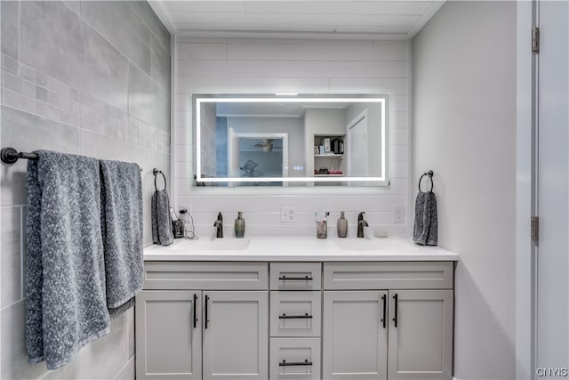 bathroom featuring backsplash, tile walls, dual sinks, and large vanity