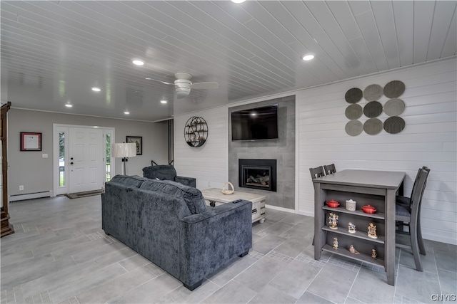 tiled living room featuring wood ceiling, a baseboard radiator, ceiling fan, and a large fireplace