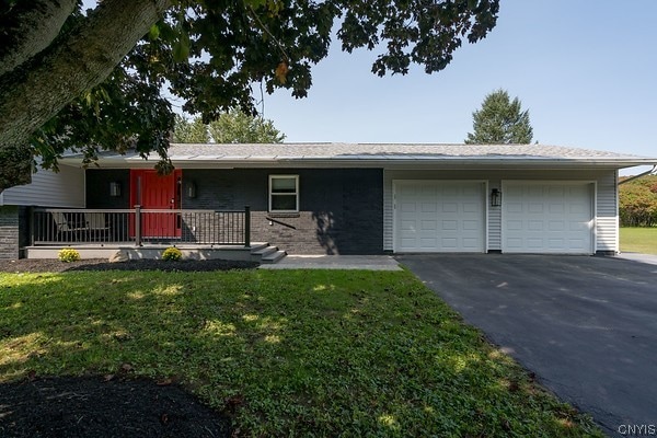 ranch-style home featuring a front yard and a garage