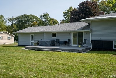 rear view of property with a yard and a deck