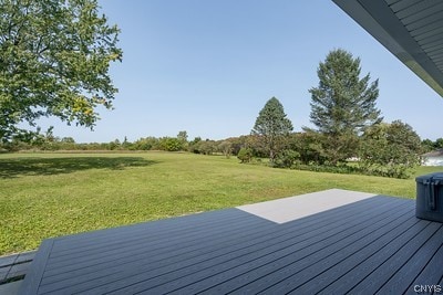 wooden terrace featuring a lawn