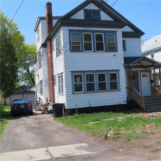 view of front of house with driveway and a chimney