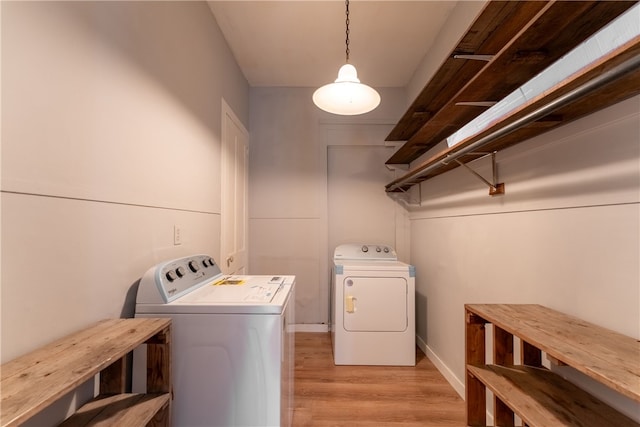 laundry room featuring independent washer and dryer and light hardwood / wood-style floors