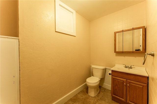 bathroom featuring tile walls, tile floors, toilet, and vanity