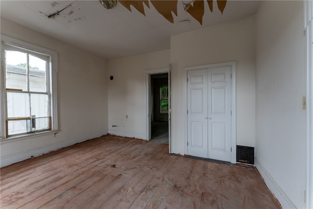 unfurnished bedroom featuring light hardwood / wood-style floors and a closet