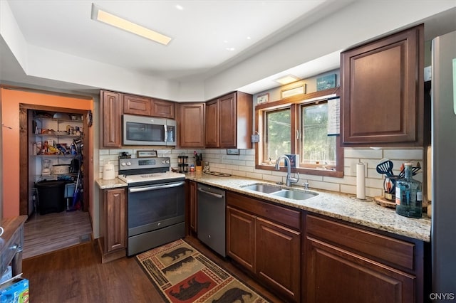 kitchen featuring sink, appliances with stainless steel finishes, dark hardwood / wood-style floors, and decorative backsplash