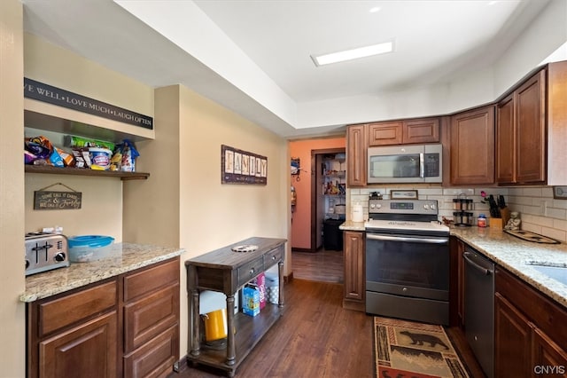 kitchen featuring dark hardwood / wood-style flooring, light stone countertops, tasteful backsplash, and stainless steel appliances