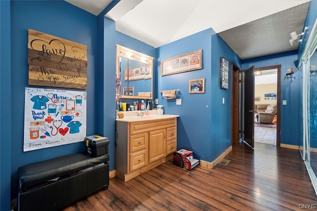 bathroom featuring wood-type flooring, vanity, and a textured ceiling