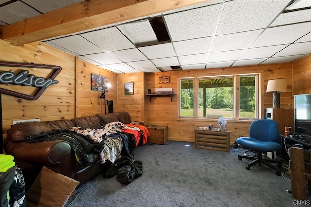 interior space featuring wood walls, carpet floors, and a paneled ceiling