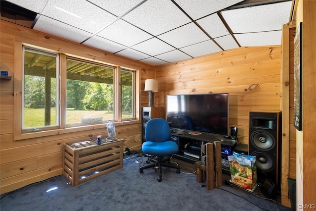 carpeted office space featuring plenty of natural light, wooden walls, and a paneled ceiling