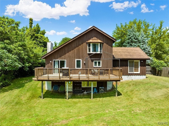 back of property with a wooden deck and a lawn