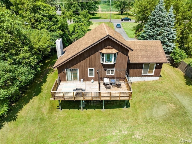 back of property with a deck and a yard