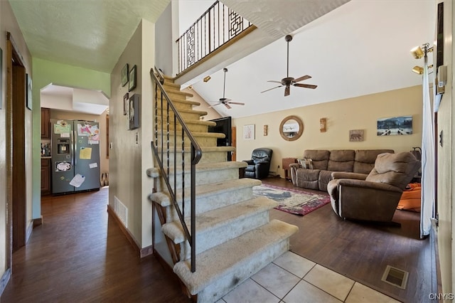 staircase featuring wood-type flooring and ceiling fan