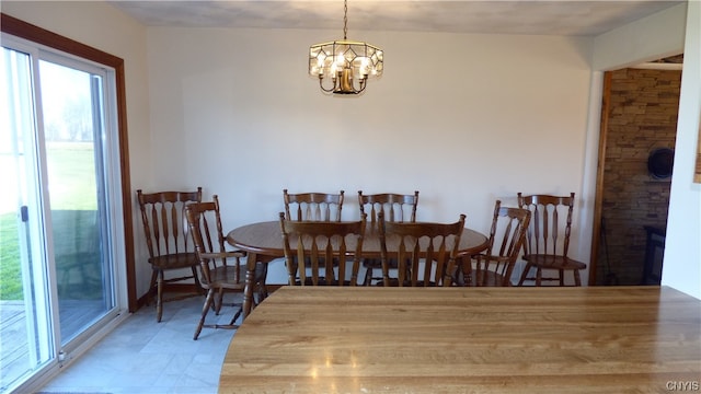 tiled dining room featuring a chandelier and a healthy amount of sunlight