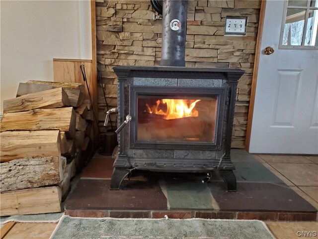 room details with dark tile floors and a wood stove