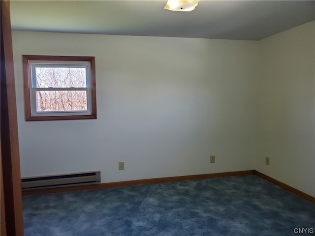 spare room featuring dark carpet and a baseboard radiator