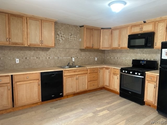 kitchen with light brown cabinetry, light hardwood / wood-style flooring, black appliances, backsplash, and sink