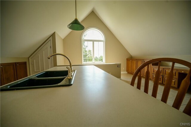 kitchen with vaulted ceiling, pendant lighting, and sink