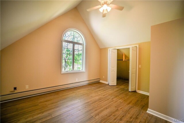 additional living space with ceiling fan, baseboard heating, light hardwood / wood-style flooring, and vaulted ceiling