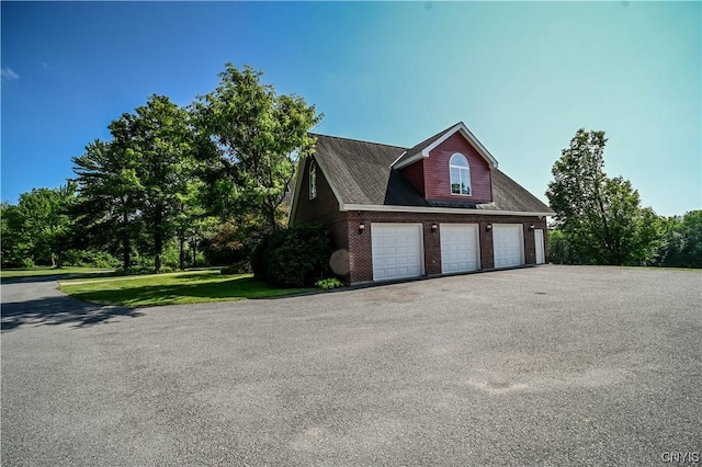 view of side of home with a yard and a garage