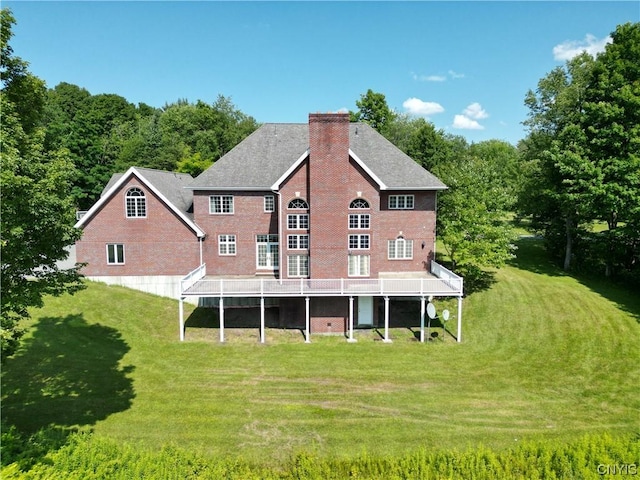 back of property with a yard and a wooden deck