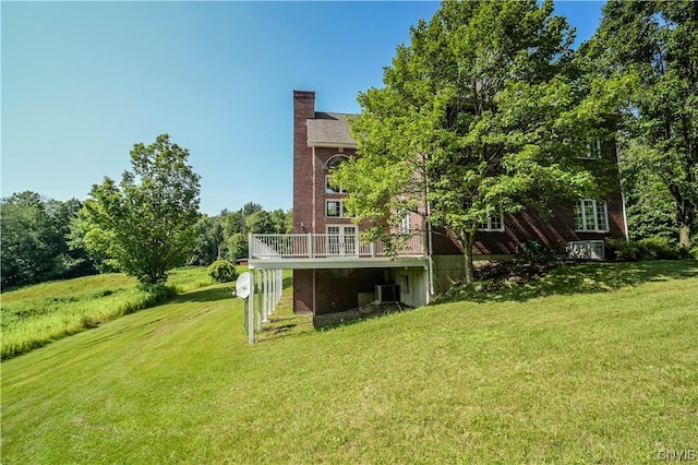 view of yard with central AC unit and a wooden deck