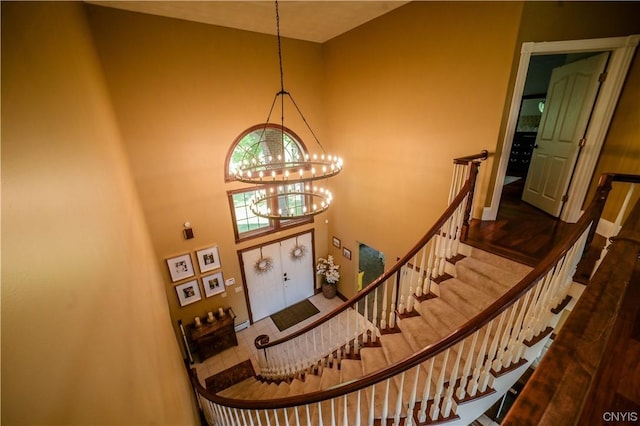 staircase featuring a high ceiling and a chandelier