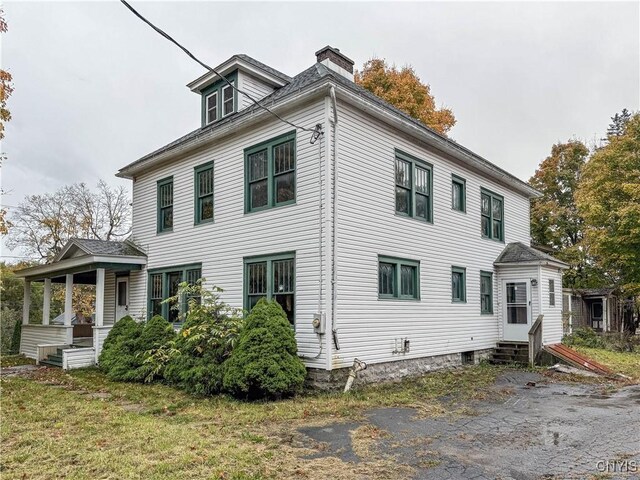 view of front of property featuring a chimney, a porch, and entry steps