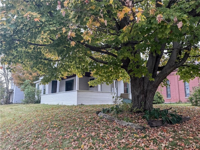 view of property hidden behind natural elements with a front yard