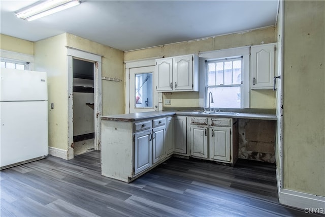 kitchen featuring dark wood-type flooring, white cabinetry, white fridge, and sink